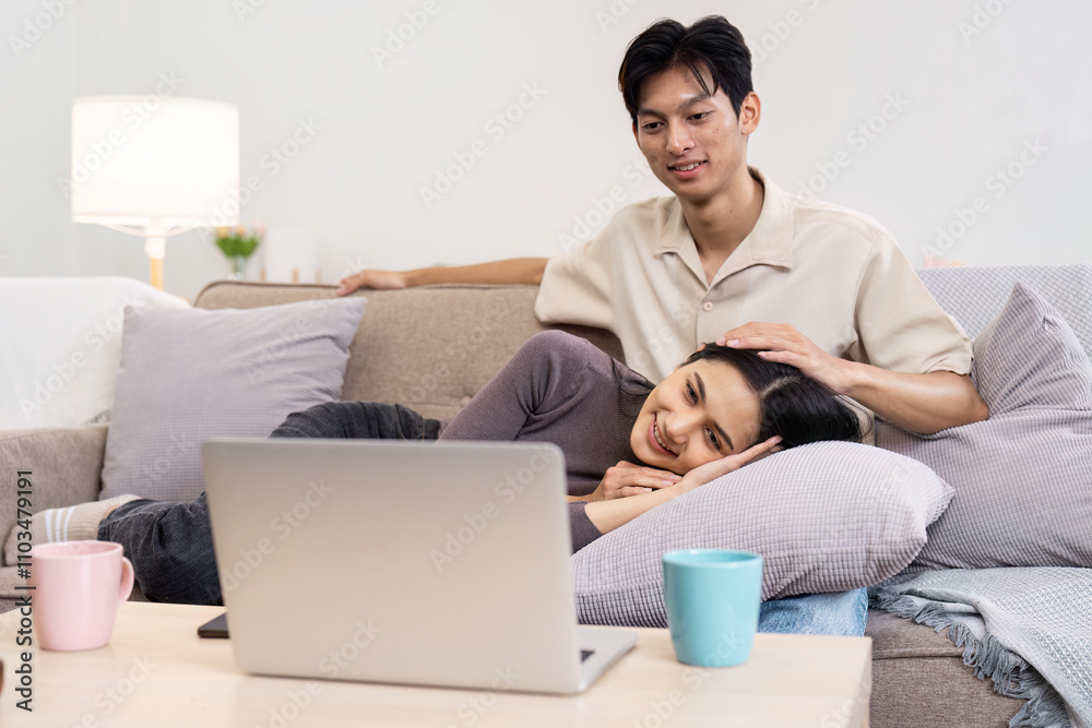 Cozy Couple Relaxing on Sofa Watching Laptop Together in Modern Living Room with Warm Lighting and Comfortable Atmosphere Cozy Couple Relaxing on Sofa Watching Laptop Together in Modern Living Room with Warm Lighting and Comfortable Atmosphere