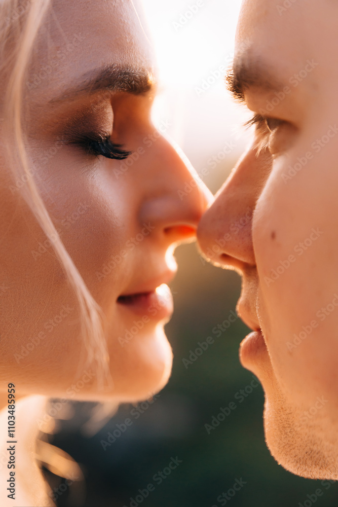 Close-up of the tender touch of the noses of the newlyweds. They look at each other with loving eyes. Close-up of the tender touch of the noses of the newlyweds. They look at each other with loving eyes.