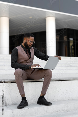 African student wearing sunglasses working with laptop	 photo