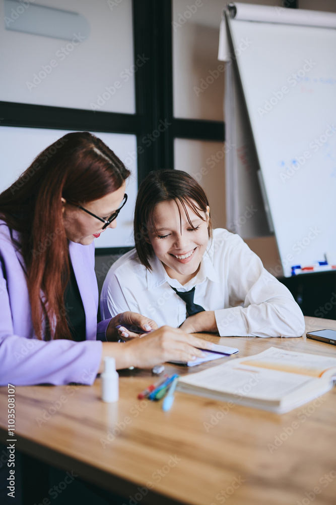 Obraz premium Schoolgirl and teacher have a lesson in the office, private lessons, distance learning