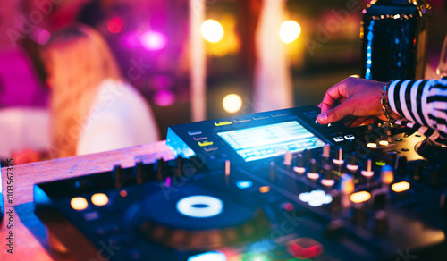 Dj playing music during winter holiday party inside cocktail bar - Entertainment and clubbing concept - Soft focus on disc jockey hand photo