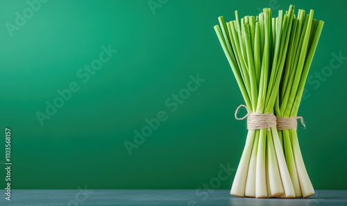 Fresh green lemongrass stalks tied together with twine, showcasing their vibrant color against green background, perfect for culinary use or decoration