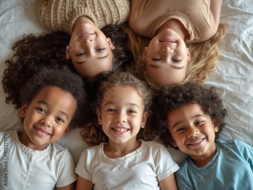 Joyful Children Lying Together on a Bed, Sharing Laughter and Smiles During a Fun Playtime at Home photo