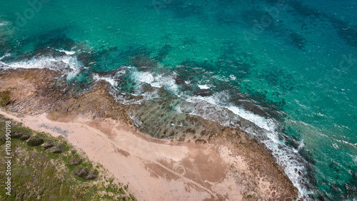 Aerial view of the coastline at Longpan Park in Taiwan with clear blue water and sandy shores