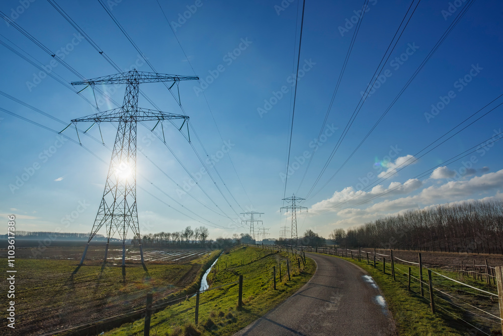 Power lines stretch across rural landscape under a clear blue sky during midday Power lines stretch across rural landscape under a clear blue sky during midday
