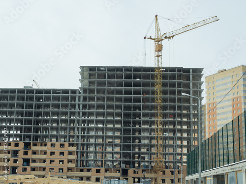 Urban Construction Site with High-Rise Building and Yellow Crane