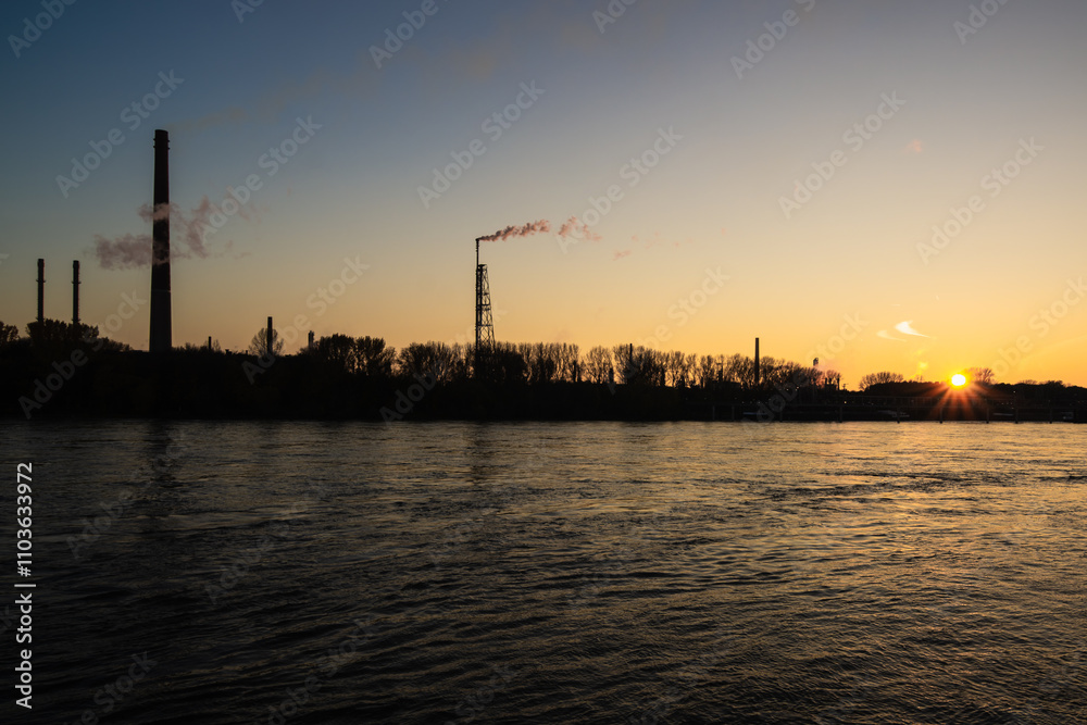 Industrial chimneys on the Rhine in the light of the setting sun. Industrial chimneys on the Rhine in the light of the setting sun.