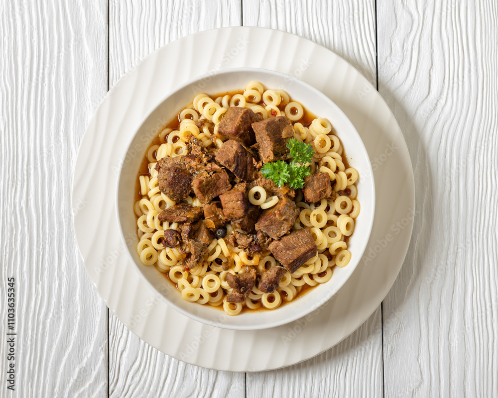 pasta rings topped with braised meat in bowl pasta rings topped with braised meat in bowl