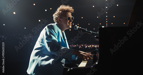 Extravagant Pop Musician Captivates the Audience with His Masterful Solo Act on a Grand Piano. Under Soft Stage Lights, Pianist Singing Happy Melodic Ballad into the Microphone