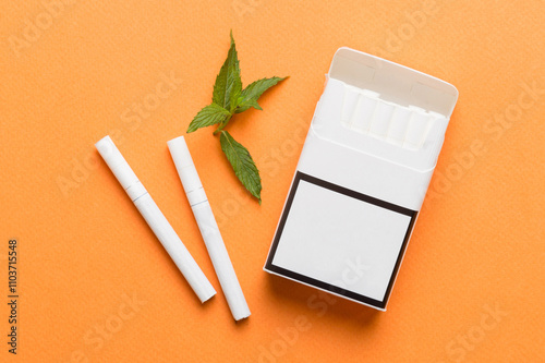 Pack of menthol cigarettes and fresh mint on colored table, Menthol cigarettes top view flat lay photo