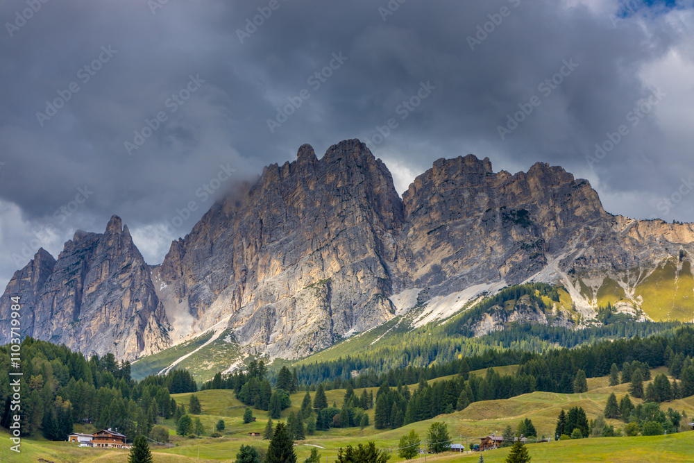 Fototapeta premium Dolomites mountains nasty weather in autumn with dark cloudy sky before the storm. Black clouds on the sky above the mountain rocky summits and peaks, stormy weather in the Dolomiti Alps, Italy