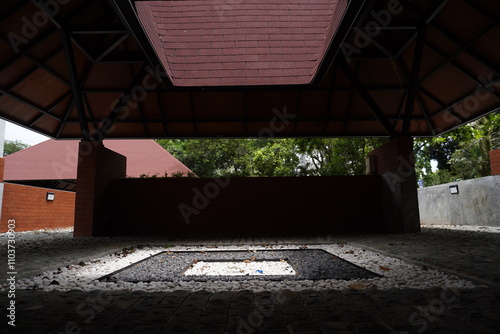 Semi-outdoor garden in a roofed area in the middle there is a box area that is exposed to sunlight coming in from the open roof