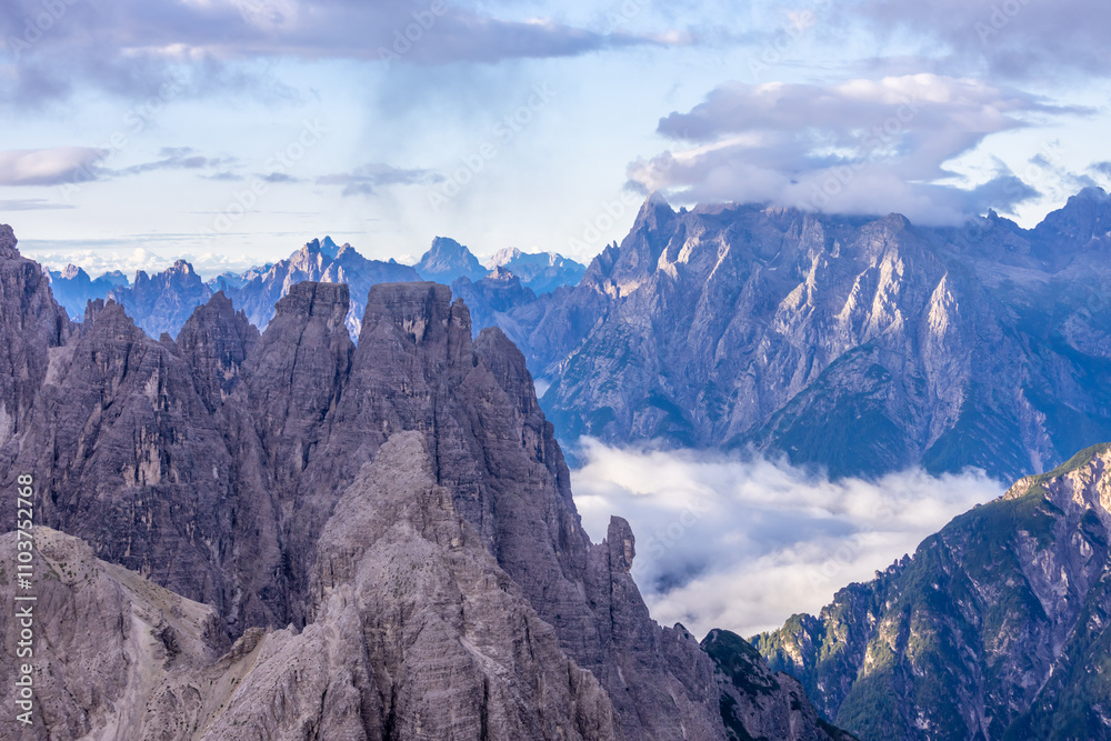 Fototapeta premium Dolomites mountains nasty weather in autumn with dark cloudy sky before the storm. Black clouds on the sky above the mountain rocky summits and peaks, stormy weather in the Dolomiti Alps, Italy