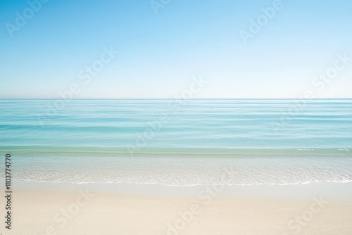 A serene beach scene with calm waters and a clear blue sky.