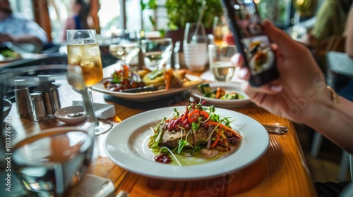 Food blogger using smart phone taking photo of restaurant