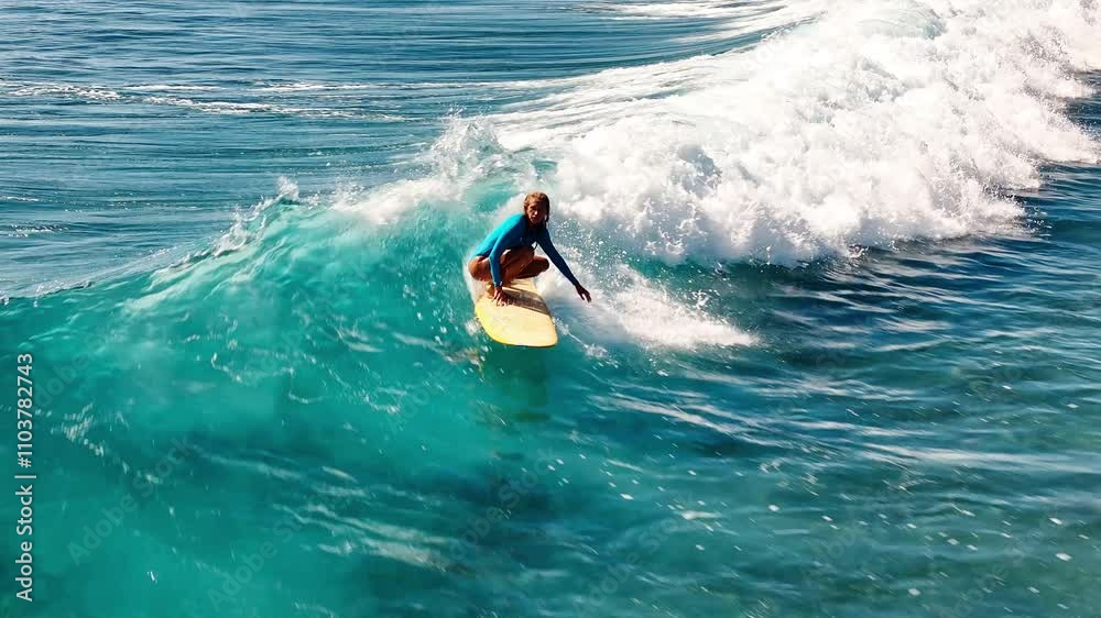 Woman surfs the wave. Aerial view of the female surfer riding the wave in the Maldives Woman surfs the wave. Aerial view of the female surfer riding the wave in the Maldives