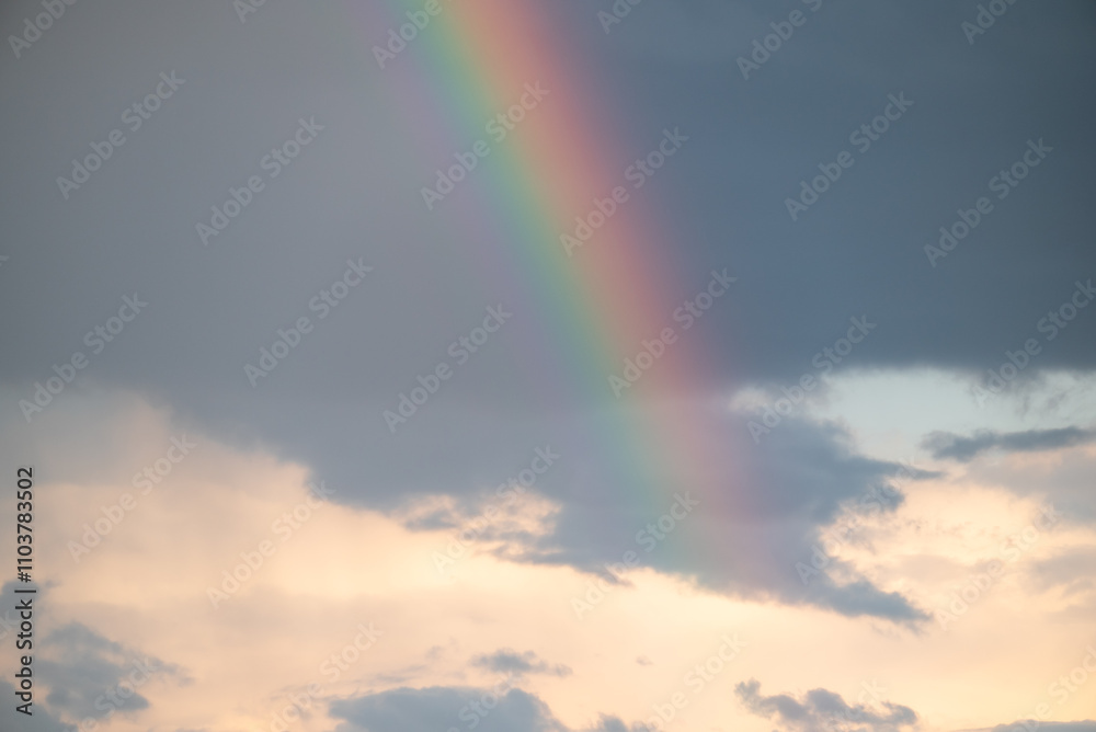 Rainbow in sky with dramatic clouds. Beautiful colorful sky after the rain