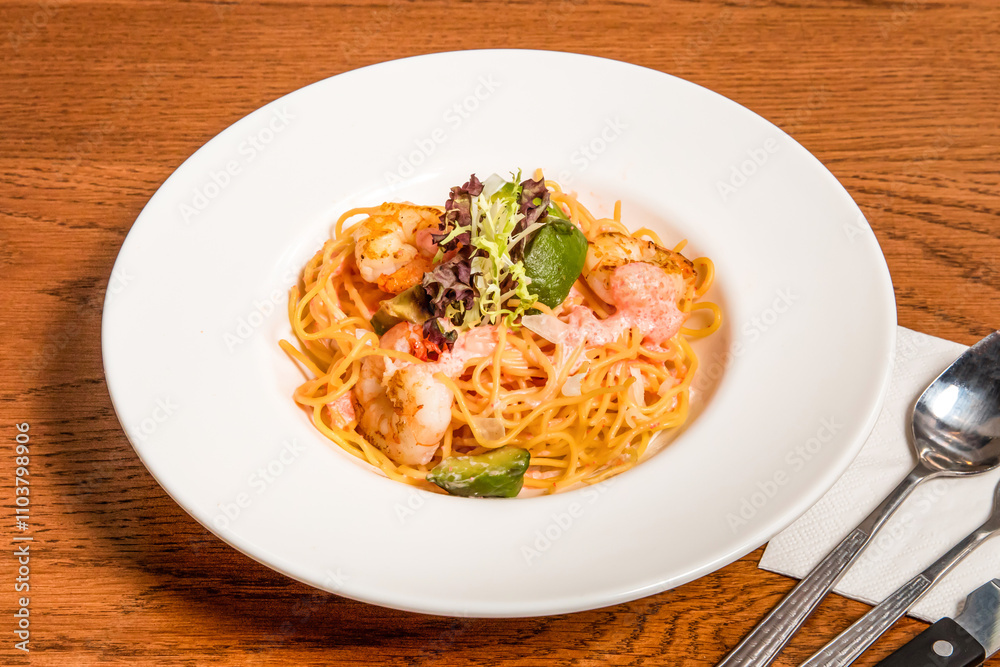 Mentaiko Shrimp and Avocado Spaghetti served in plate isolated on wooden table side view of italian cousin Mentaiko Shrimp and Avocado Spaghetti served in plate isolated on wooden table side view of italian cousin