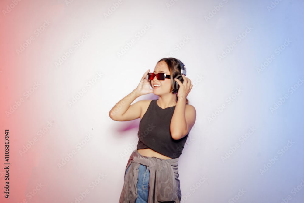 cheerful young asian dancer woman wearing headphones and glasses listening to music