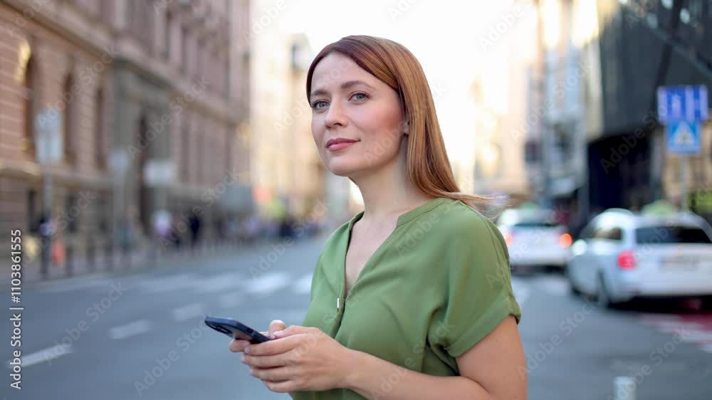 Beautiful redhead woman using smartphone on the street Beautiful redhead woman using smartphone on the street