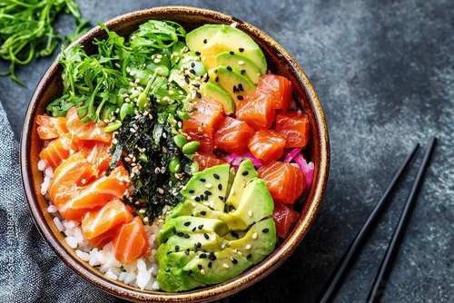 Superfood Bowl.Poke bowl with salmon, avocado,seaweed and rice on a dark background.The concept of healthy food, lunch at work or school.