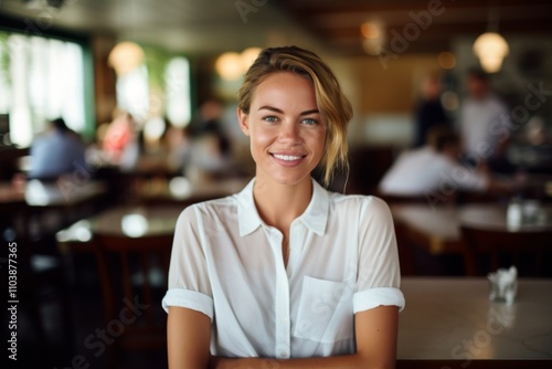 Smiling portrait of a young female waitress in cafe
