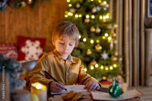 Sweet blond child, cute boy, playing with christmas toys on Christmas, beautifully decorated home for Christmas, cosy place photo