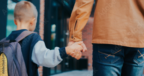 Valokuva View from behind of small Caucasian boy walking together with his caring dad