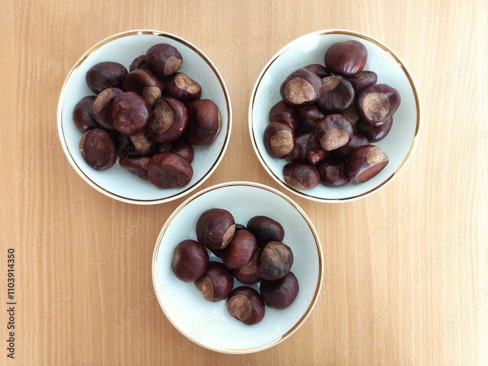 Obraz premium Shiny brown chestnuts on the table