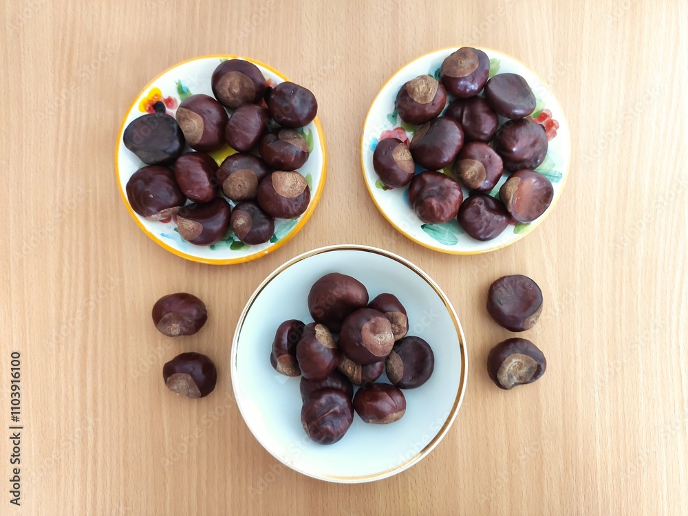 Obraz premium Shiny brown chestnuts on the table