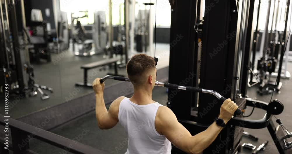 Professional sportsman maintains steady rhythm as pushes and pulls handles of training machine. Athlete concentrates on building biceps slow motion