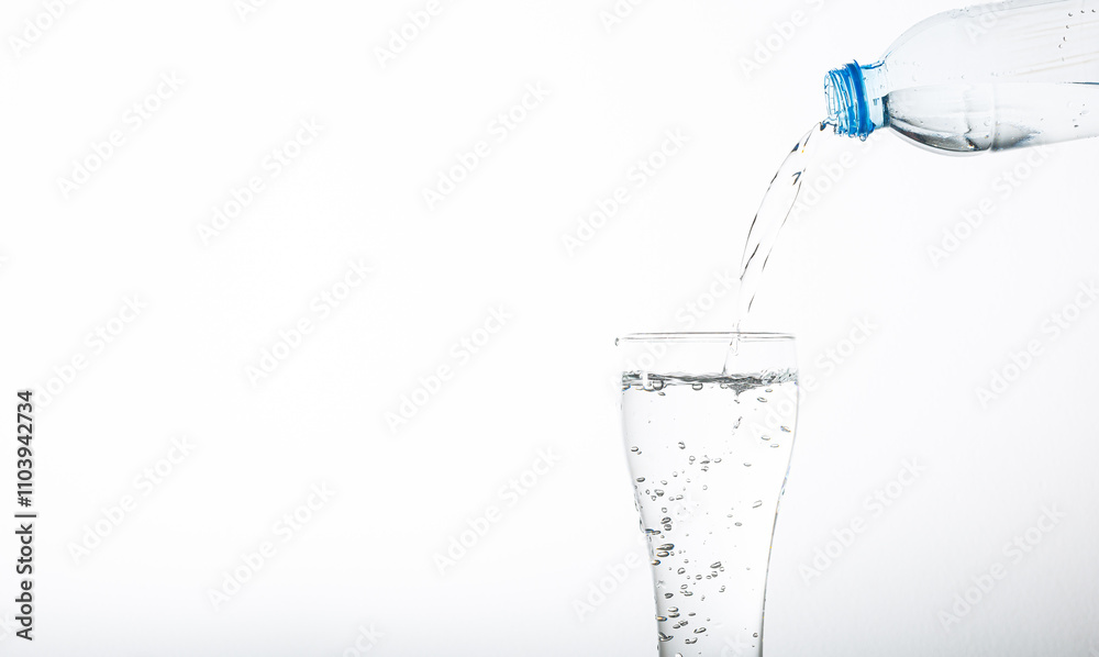 Pour drinking water into a glass isolated on white background,Pouring water from bottle into glass on blue background Pour drinking water into a glass isolated on white background,Pouring water from bottle into glass on blue background