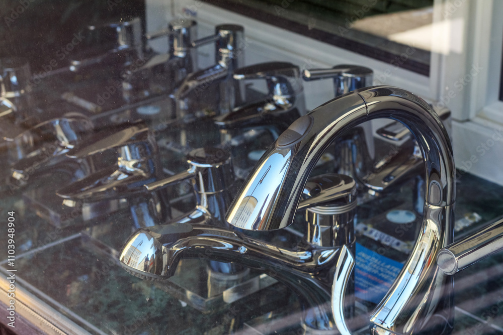 Chrome water taps are placed behind the glass in the shop stand Chrome water taps are placed behind the glass in the shop stand