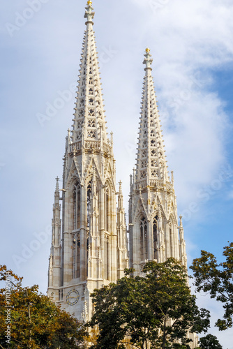 Beautiful church towers through the trees against a blue sky