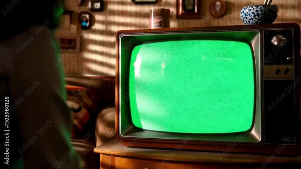 a person watching old tv with green screen