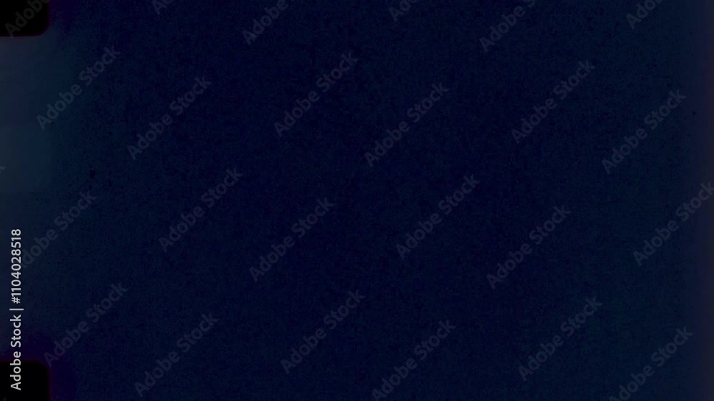 Midnight Blue Film Grain Texture,High-resolution scan of a 35mm film frame with deep blue tones and sprocket holes for creative projects.