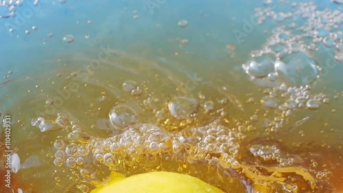 Lemon slices falling and splashing into iced tea, creating refreshing ripples and bubbles in slow motion 300fps