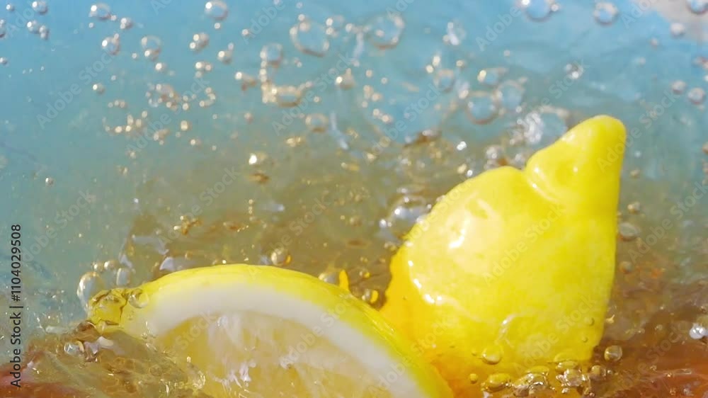 Lemon slices falling and splashing into iced tea, creating refreshing ripples and bubbles in slow motion 300fps Lemon slices falling and splashing into iced tea, creating refreshing ripples and bubbles in slow motion 300fps