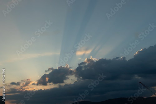 This is such a beautiful image of rays shooting out from the clouds. The sun is seen here beaming its light for all to see. A pretty clear blue sky is here.