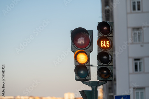 Traffic lights show red and green signals, indicating movement for vehicles and buses.