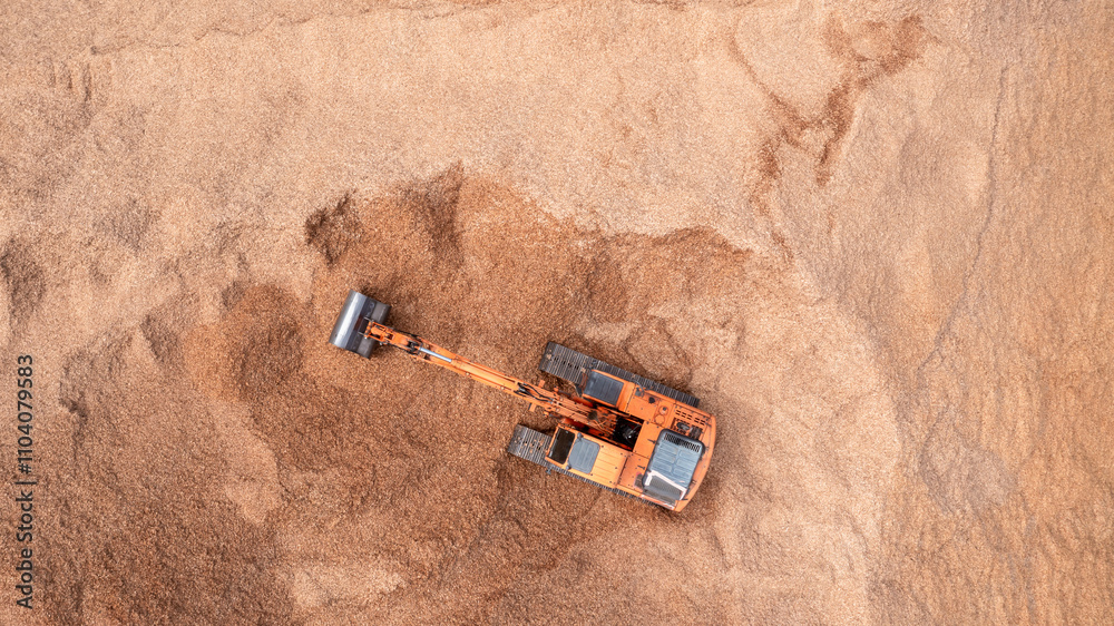 Obraz premium Aerial view road motor grader flatting dirt road surface, Motor grader road construction grader industrial machine construction site new road, Aerial view group excavator working on construction site.