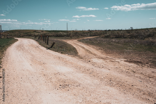 A ramification Country dirt road diverges in two directions - to a right, to a left. Life choices, uncertainty concept. Routes, walkways, trails. Spanish landscape. Two narrow paths Divergence of path photo