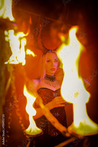 A beautiful woman with devilish horns on a red blood like smoky hell concept background. photo