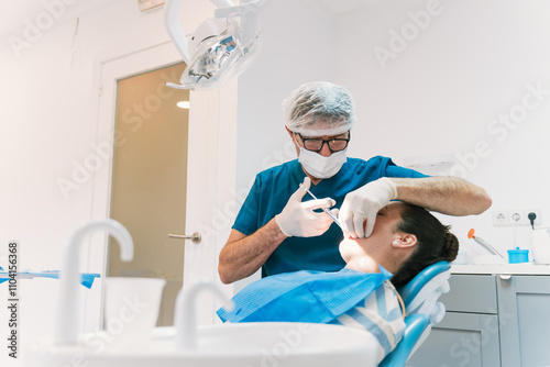 Dentist performing procedure in modern dental clinic office