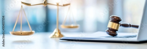 Gavel on laptop with justice scales in background.