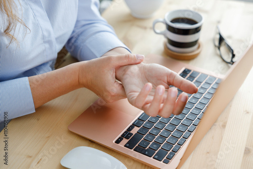Young woman with wrist pain while using laptop