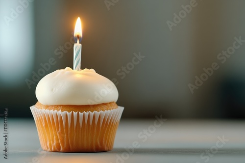 Delicately decorated birthday cupcake with festive candle