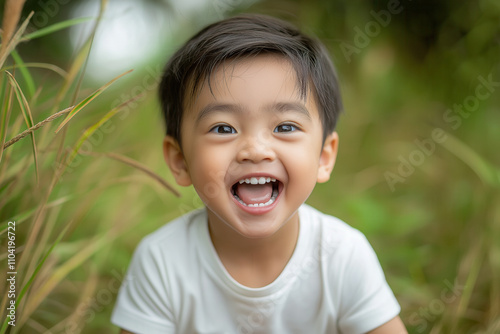 A playful Asian boy in a simple white t-shirt and khaki shorts, making silly faces at the camera