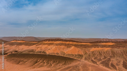 Moroccan Sahara Desert, ancient black volcanic mountains, the Sahara River Oued Ghris, stunning Acacia trees, wild camels, and desert camp, landscape where golden sand dunes merge with green plants