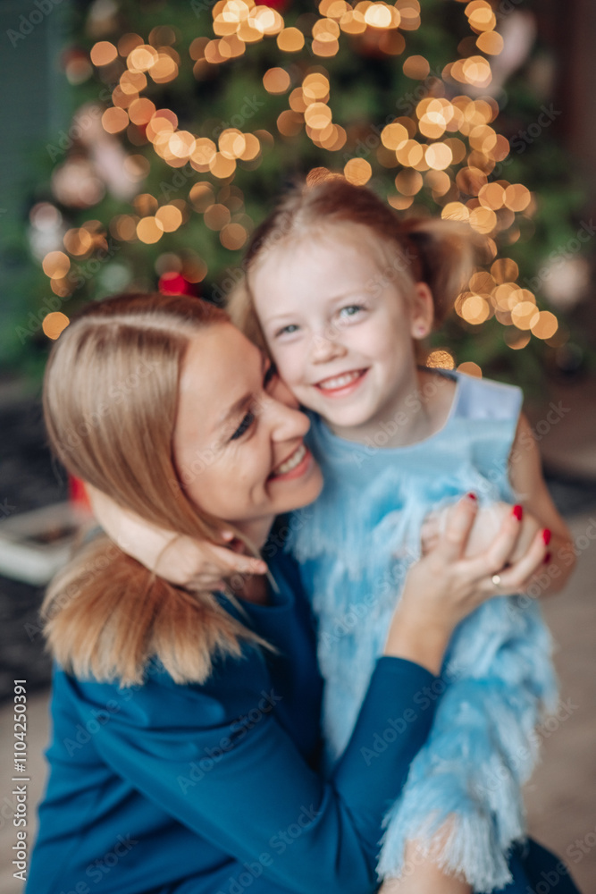 Little girl and her mom on Christmas morning at home. Girl is sad about something and mother is hugging her. Little girl and her mom on Christmas morning at home. Girl is sad about something and mother is hugging her.